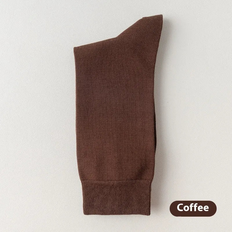 Five pairs of men's solid colour mid-calf socks made from combed cotton, shown in assorted colours.