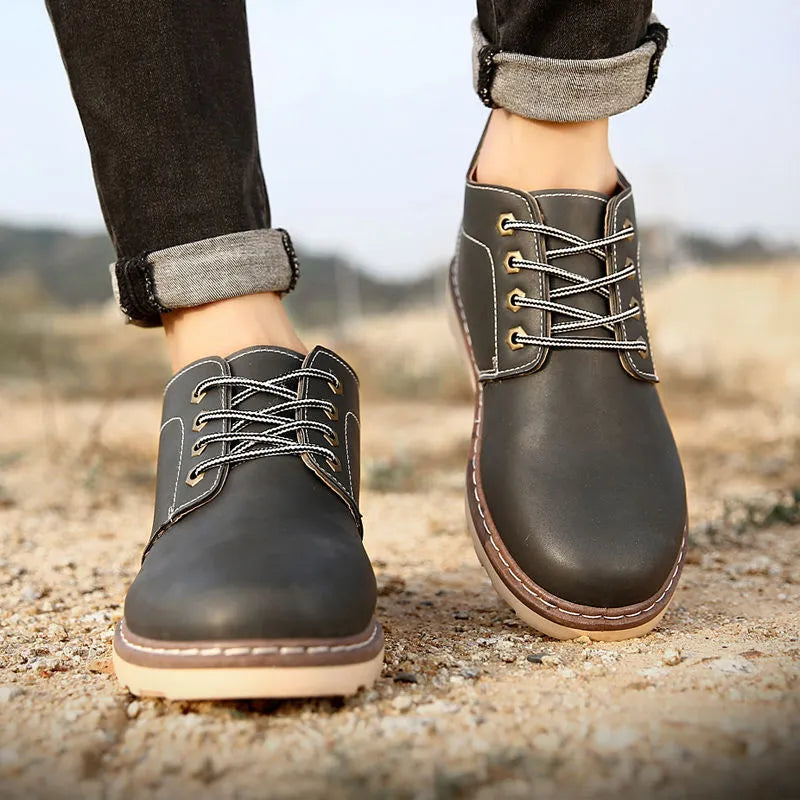 Men's black mid-top waterproof leather boots with rubber soles on size label