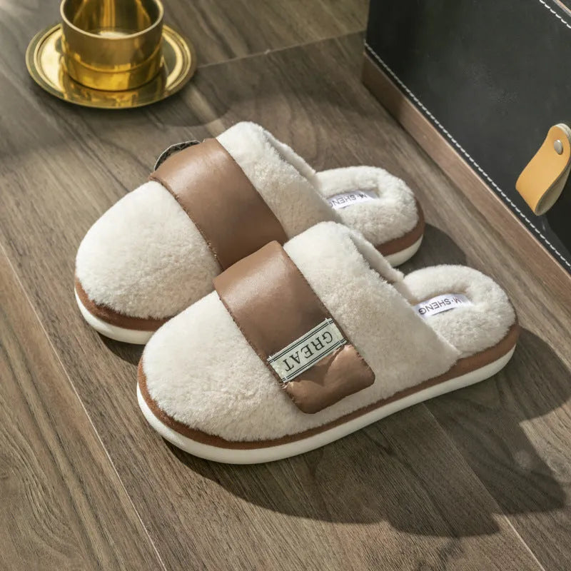 Beige plush velcro slippers with a round toe and non-slip plastic sole on a wooden floor.