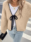 Grey women's cardigan with lace-up front and crocheted flower detail on a hanger.
