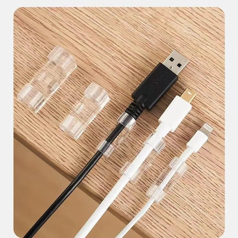 Transparent plastic self-adhesive cable management clips on a white background.