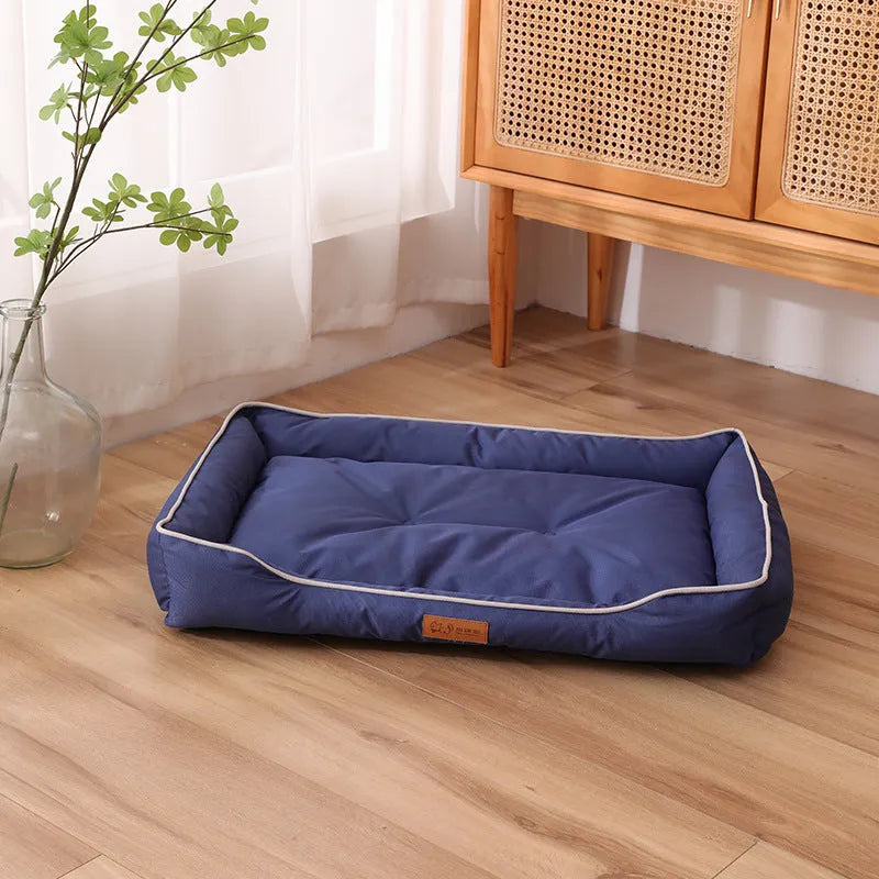 Grey waterproof dog sofa bed with raised edges on wooden floor
