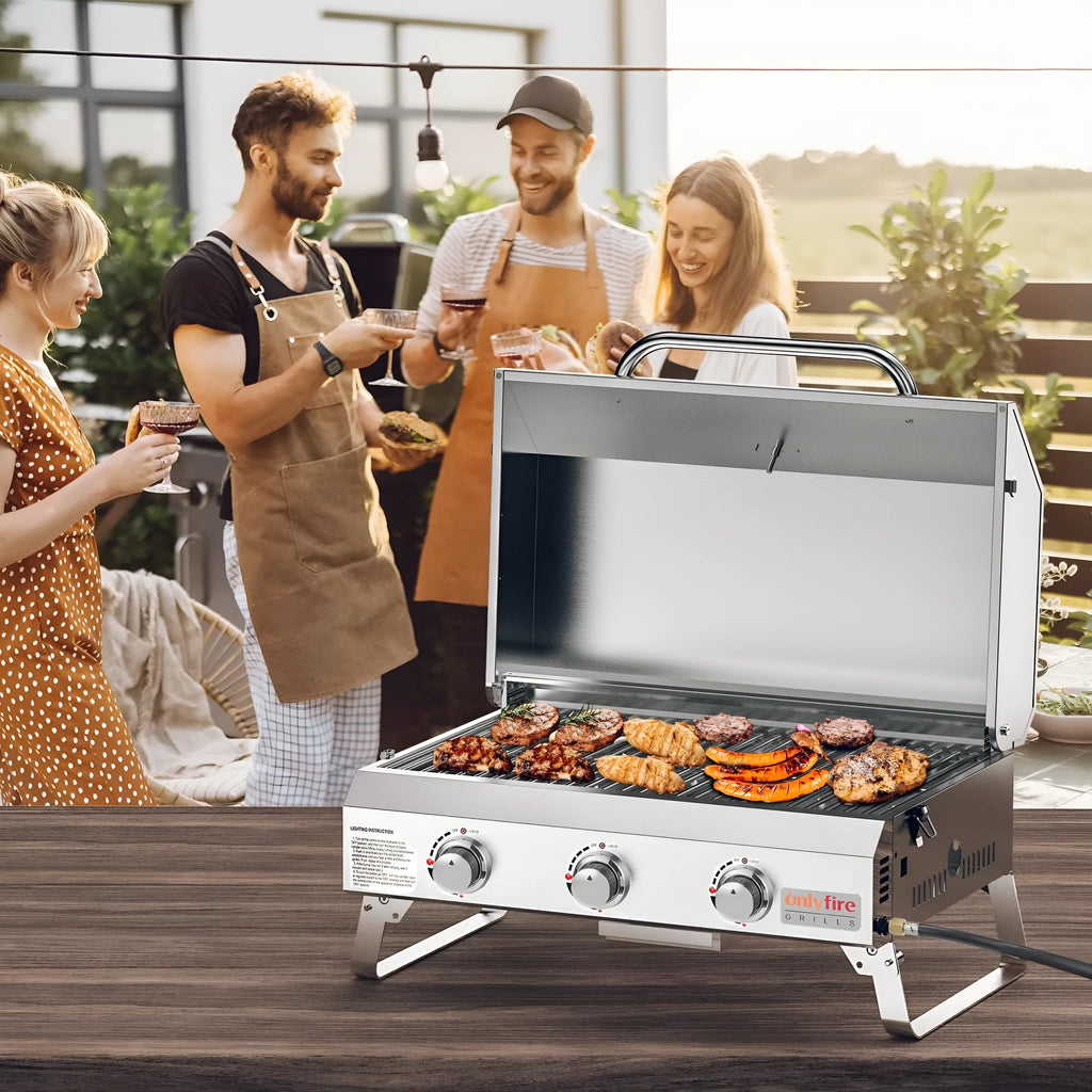 Silver desktop gas barbecue grill with three burners and foldable legs.