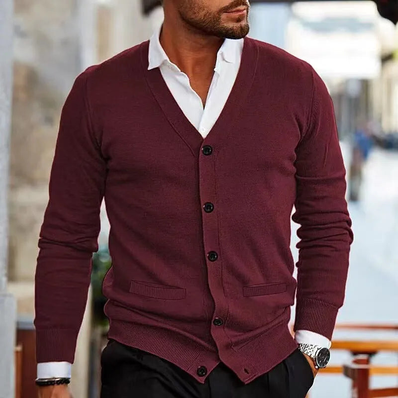 A man wearing a slim-fit, long-sleeve acrylic cardigan sweater coat in a dark green colour.