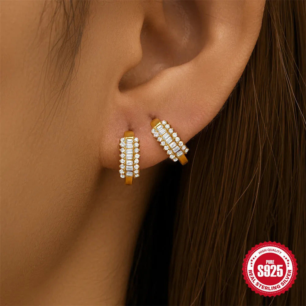 Sterling silver geometric stud earrings with small round diamond-like accents in gold and silver finishes.