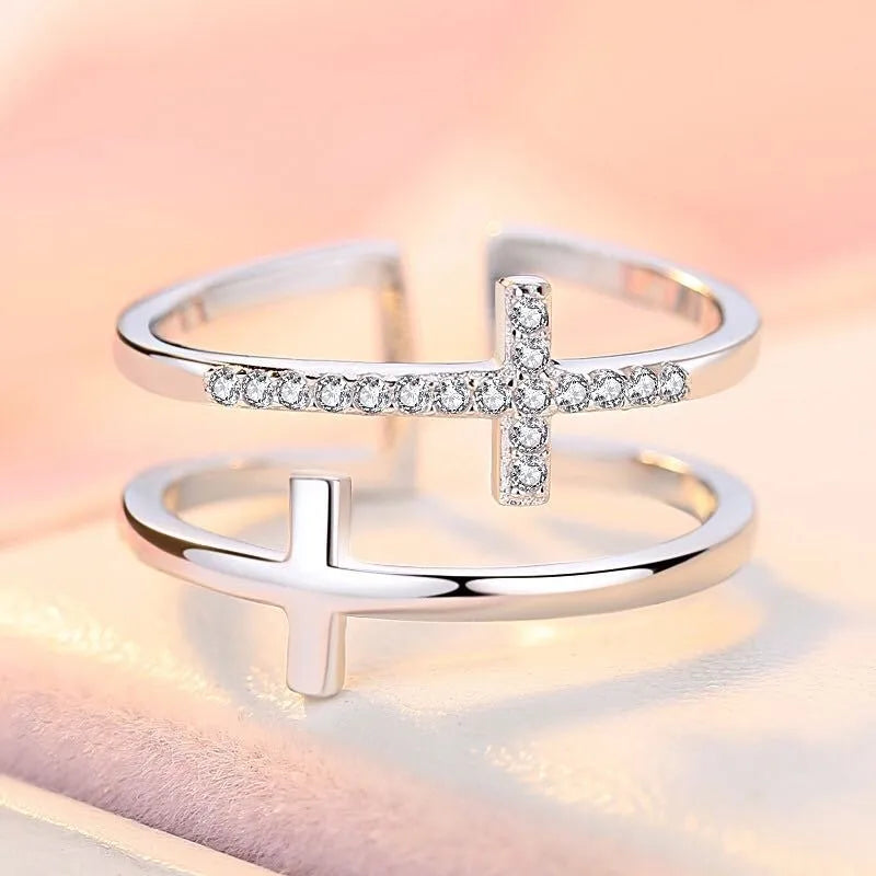 Adjustable open copper ring with a miniature double cross design inlaid with zircon stones.