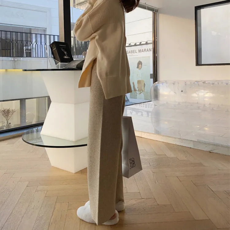 Women's cream white high-waisted wide-leg knitted trousers with a straight leg and drooping hem.