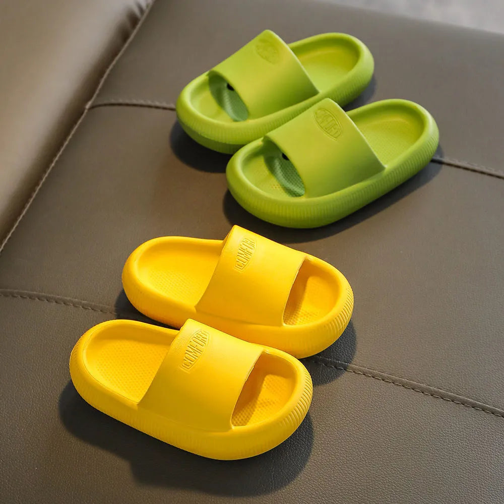 A pair of bright blue, one-piece EVA children's slippers with a textured non-slip sole, shown on a wooden floor.