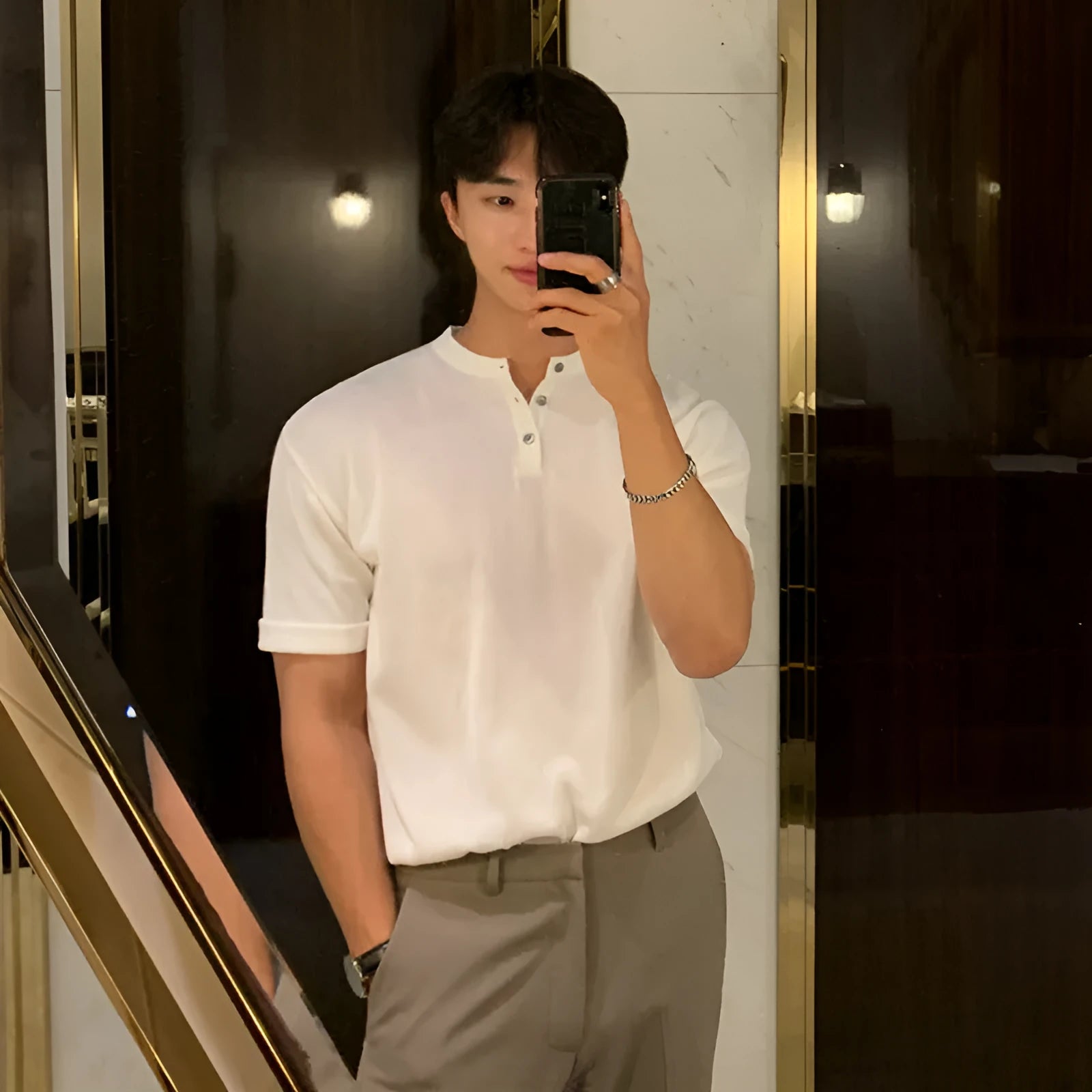 Man wearing a black slim-fit short-sleeved knitted ice silk bottoming shirt.