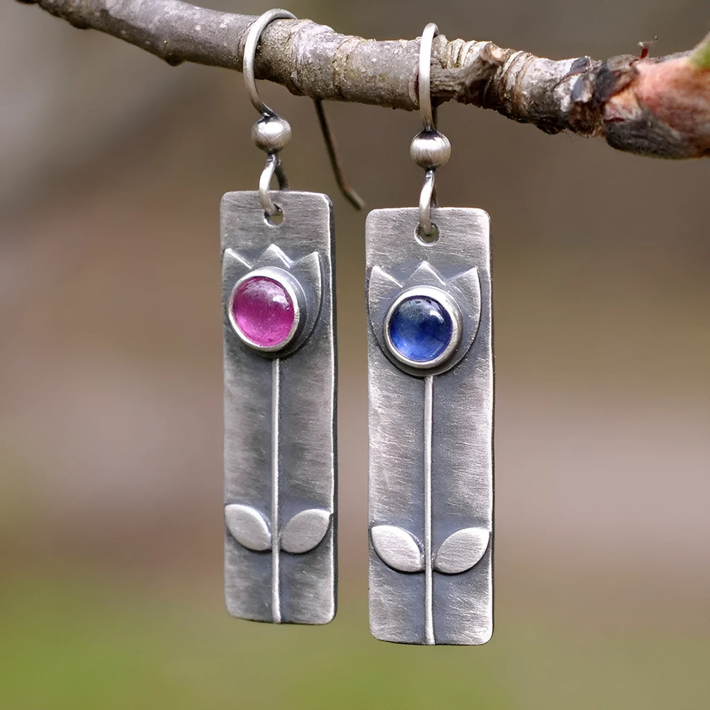 Pair of antique finish red sapphire geometric ellipse earrings with retro style on a white background.
