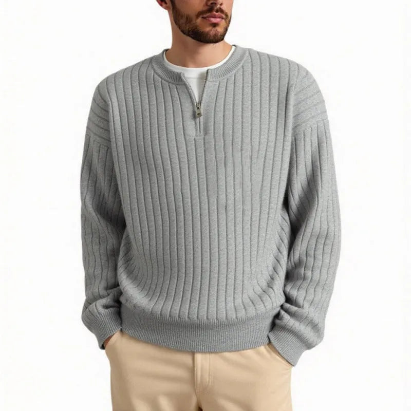 Man wearing a loose grey half-zip textured knit pullover sweater.