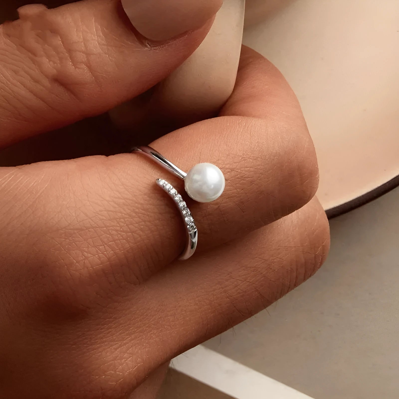 Sterling silver adjustable ring with shell pearl centrepiece on grey background
