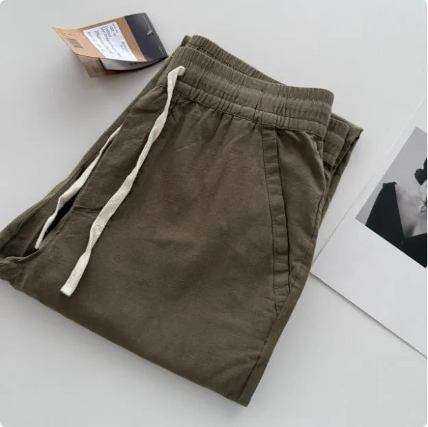 Men's loose-fitting straight-leg casual trousers with a drawstring waistband, shown in a beige colour.
