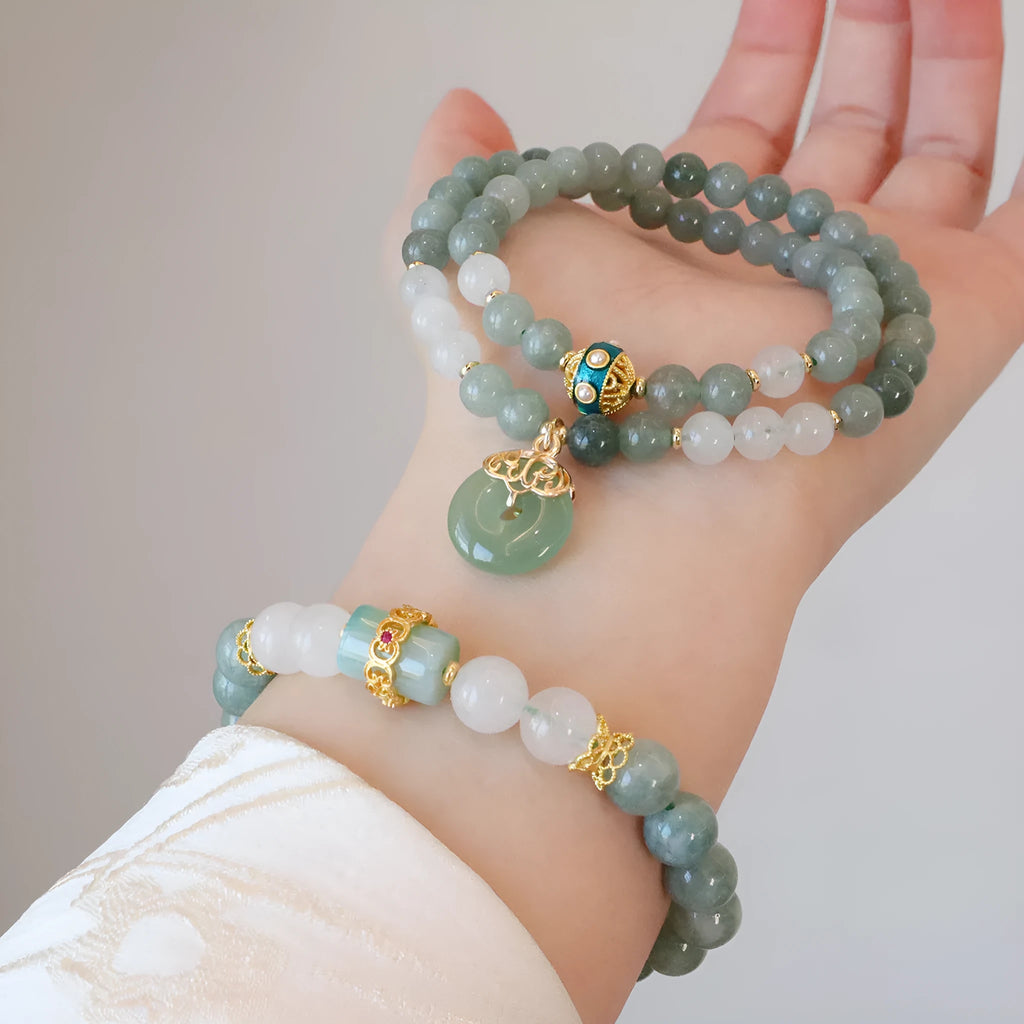 Close-up of a women's Myanmar jade bracelet with a geometric safety buckle pendant and lucky beads.
