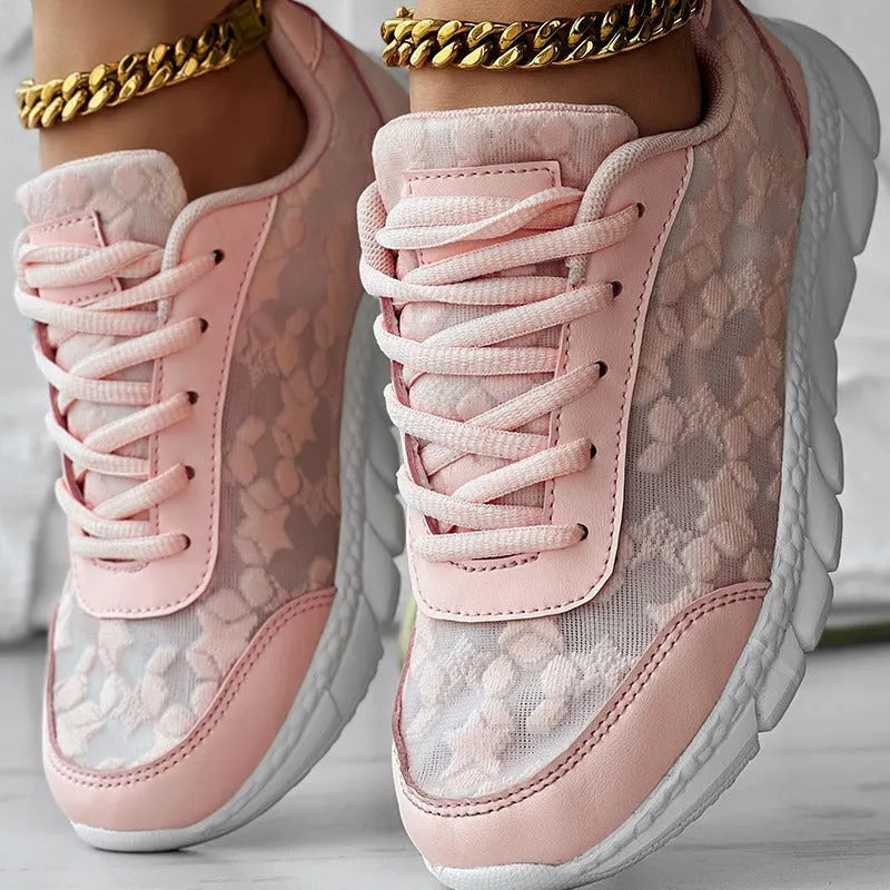 Women's white canvas running shoes with a flat heel and soft sole on a plain background.