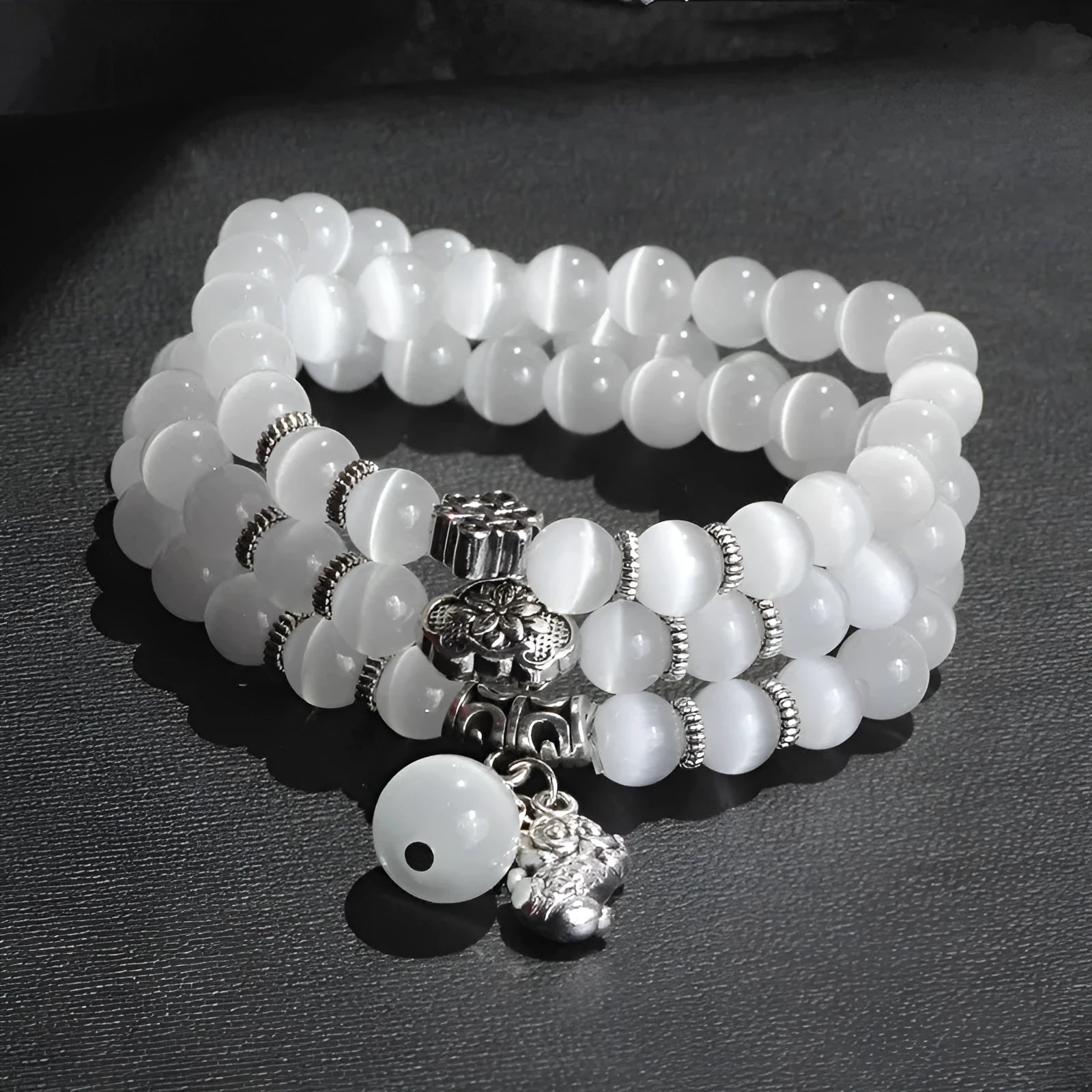 Women's opal bracelet with three interlocking rings, a Lucky Cat charm, and geometric stones in various colours.