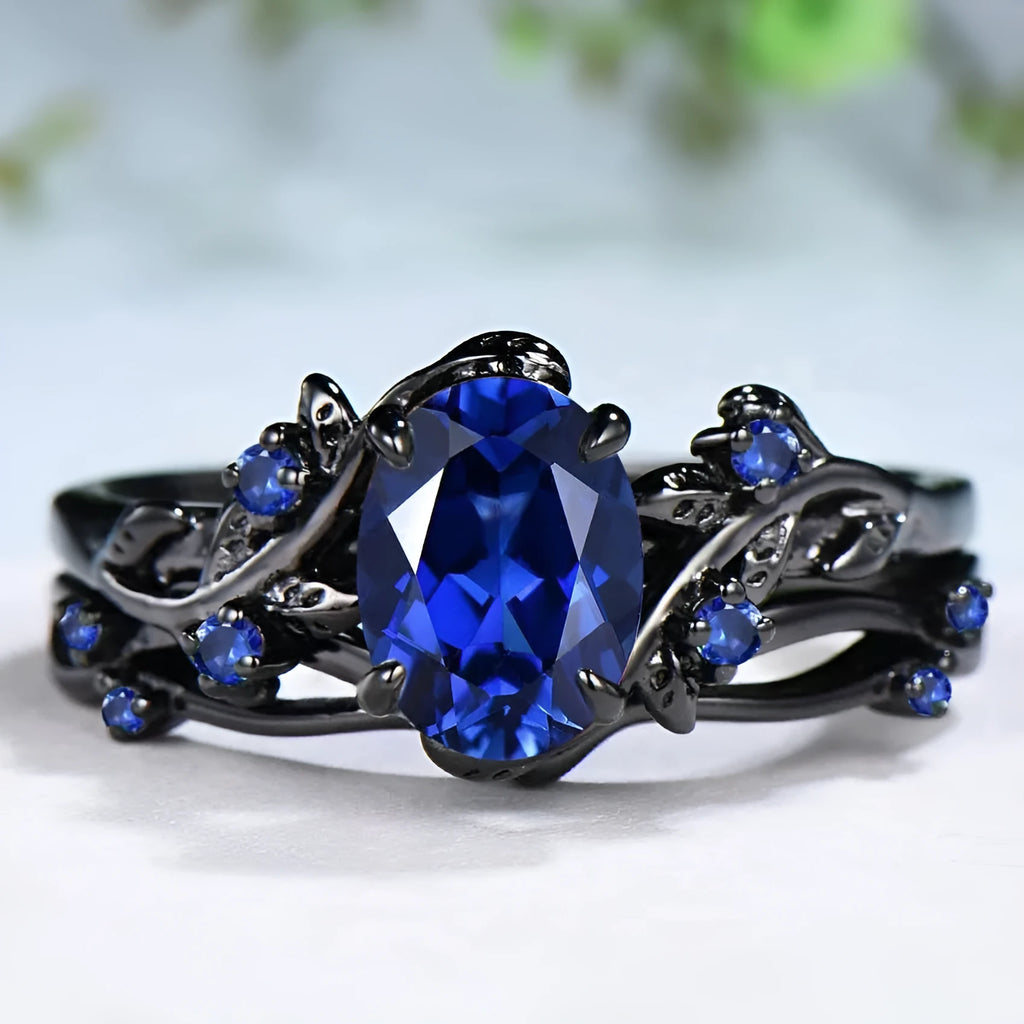 Geometric gun black couple ring for women with a single inlaid navy blue rhinestone.
