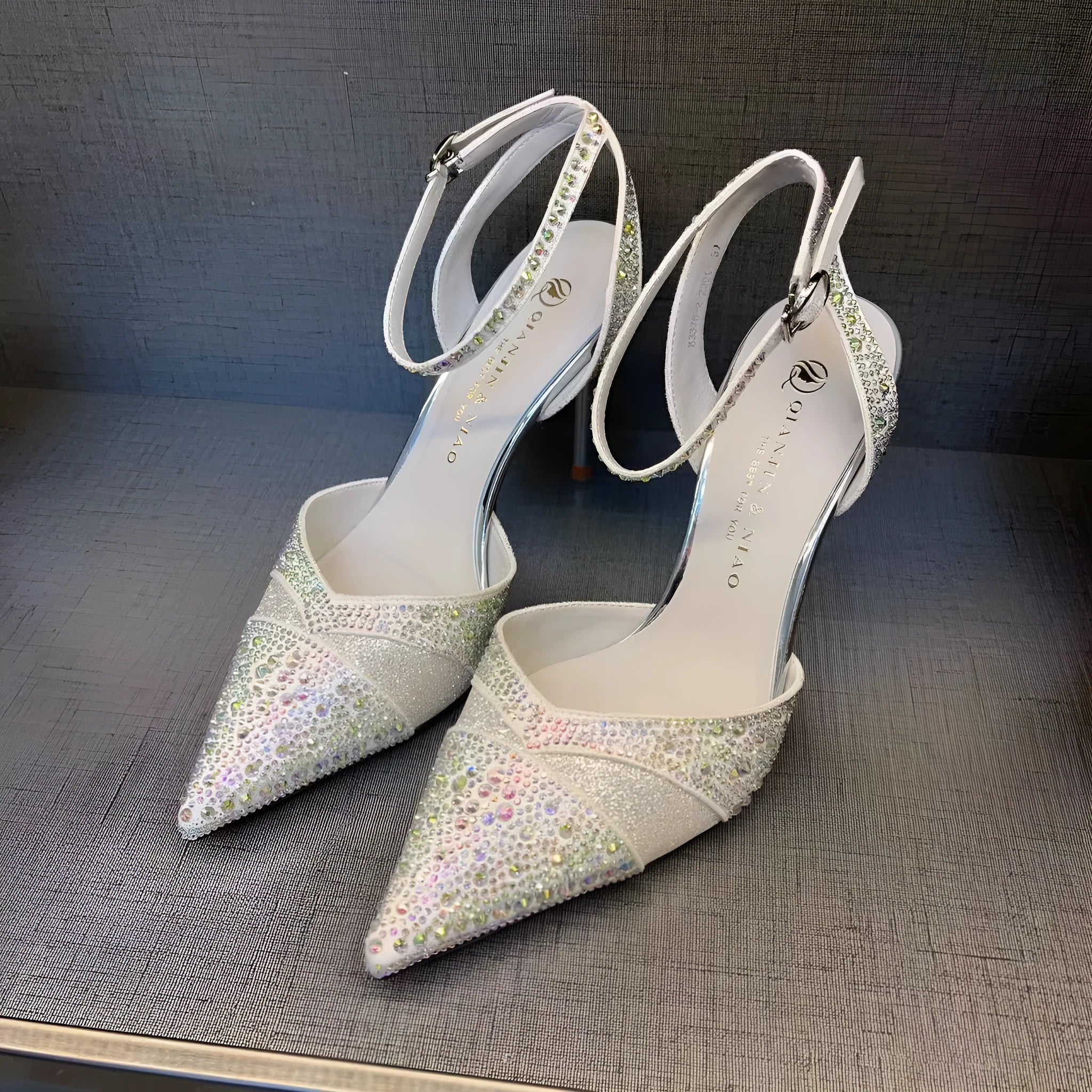 Women's black and silver hollow-cut stiletto heels with a pointed toe and shallow mouth design.