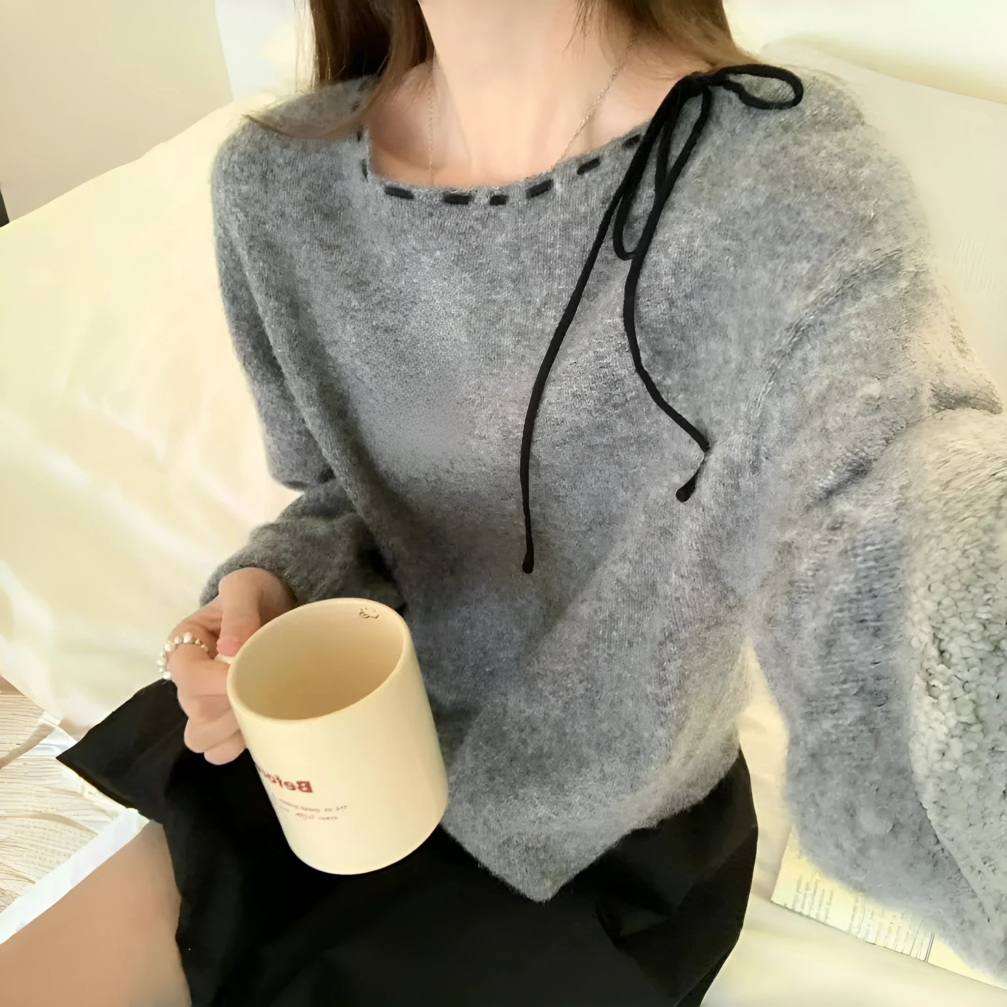 Grey loose-fitting women's pullover knitwear top on a hanger.