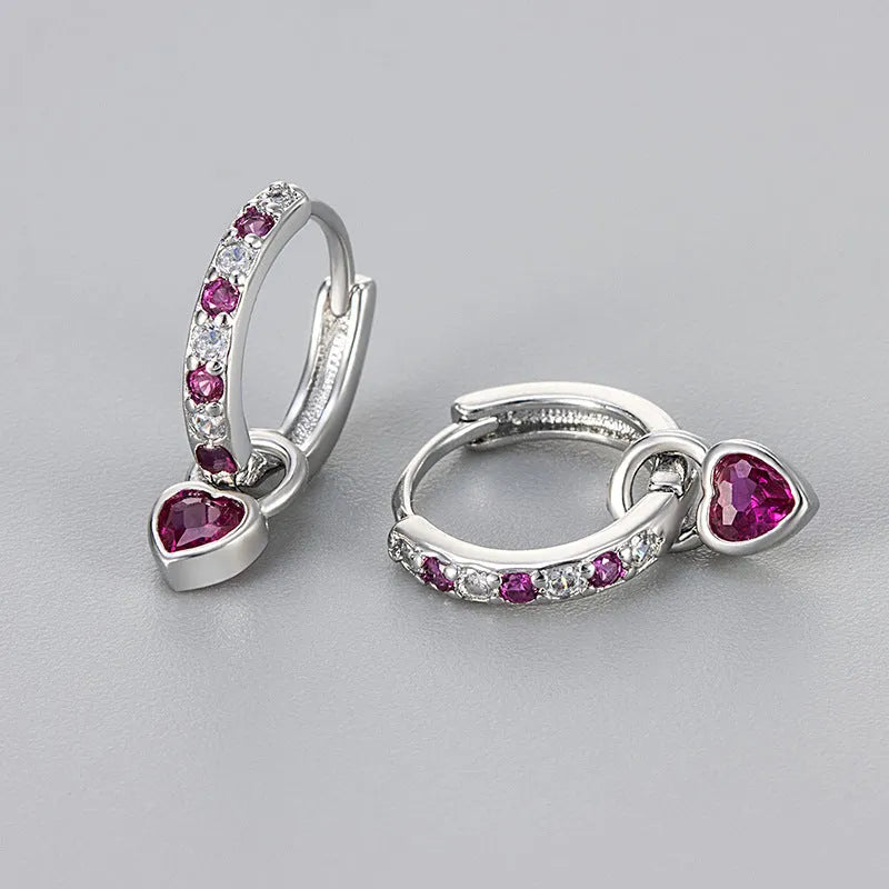 Women's heart-shaped earclip earrings with a coloured zircon or stone centre, in gold or white gold colour.