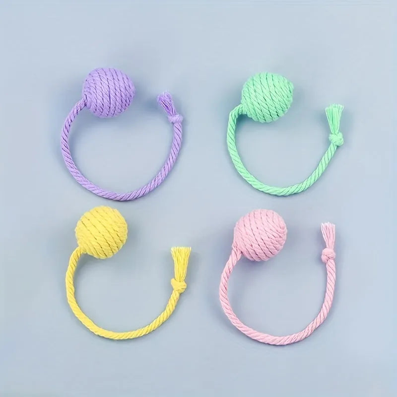 Cat toy ball with rope attachment and bell inside, shown in green, pink, purple, and yellow colour options