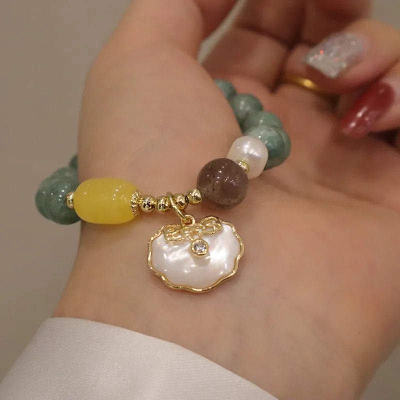 Women's green jade shell bead bracelet showing natural gemstone colour tones