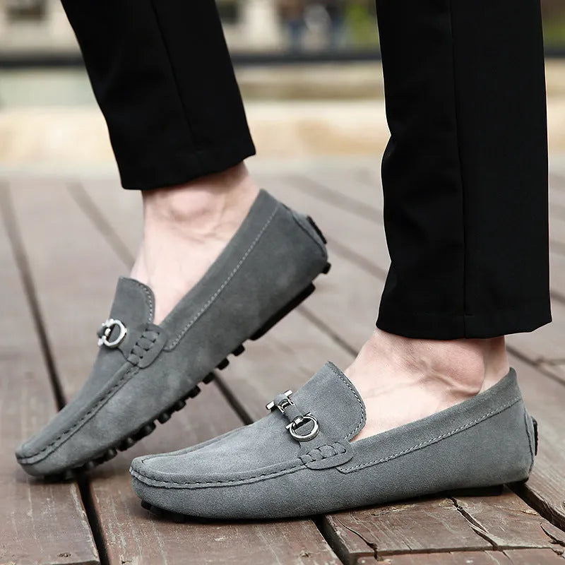 Men's black matte cowhide slip-on shoe with square toe and visible stitching on a plain background.