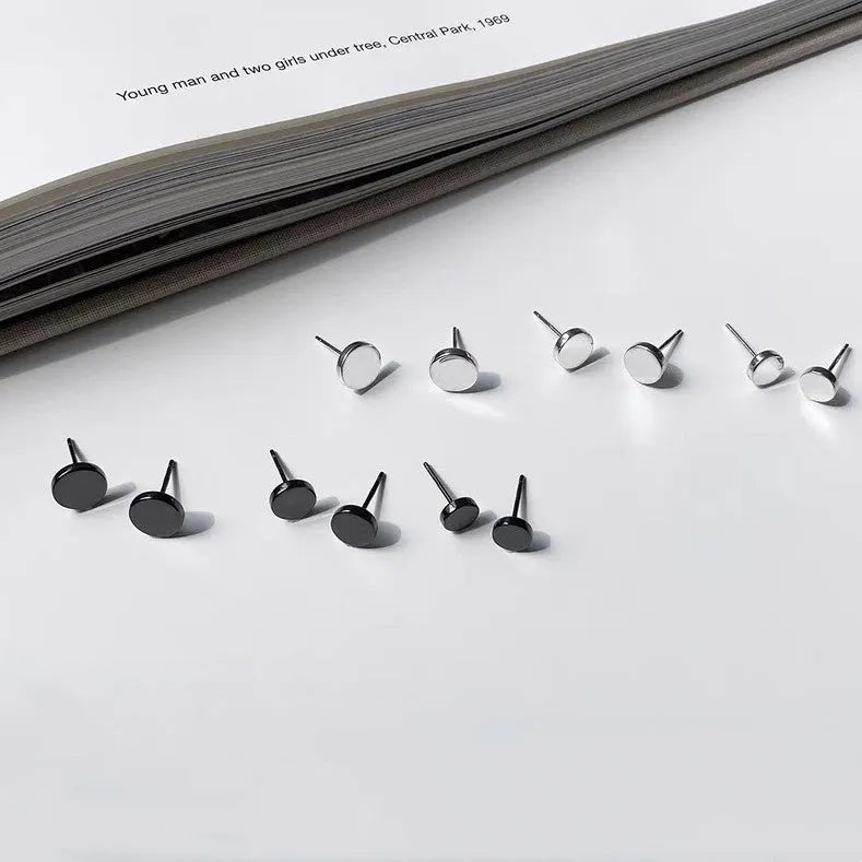 A pair of round, flat bone stud earrings in sterling silver, showing silver and black colour options.