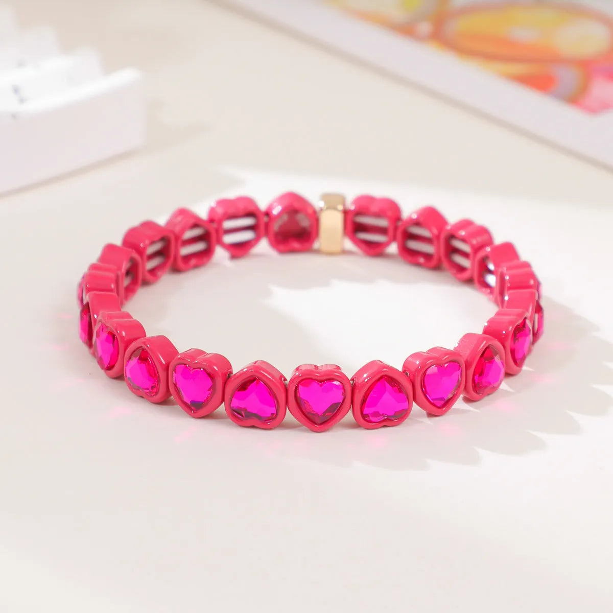 Rainbow enamel heart charm bracelet on alloy base with diamond treatment, stretch band, multicolour design.