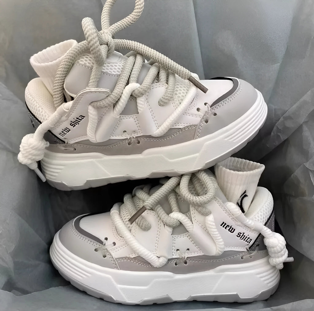 Women's grey retro chunky sneakers with thick sole and front lace-up, shown on a foot