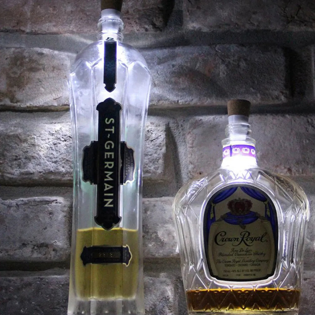 White plastic USB-rechargeable LED bottle cap cork light with micro-USB port, shown next to a whisky bottle.