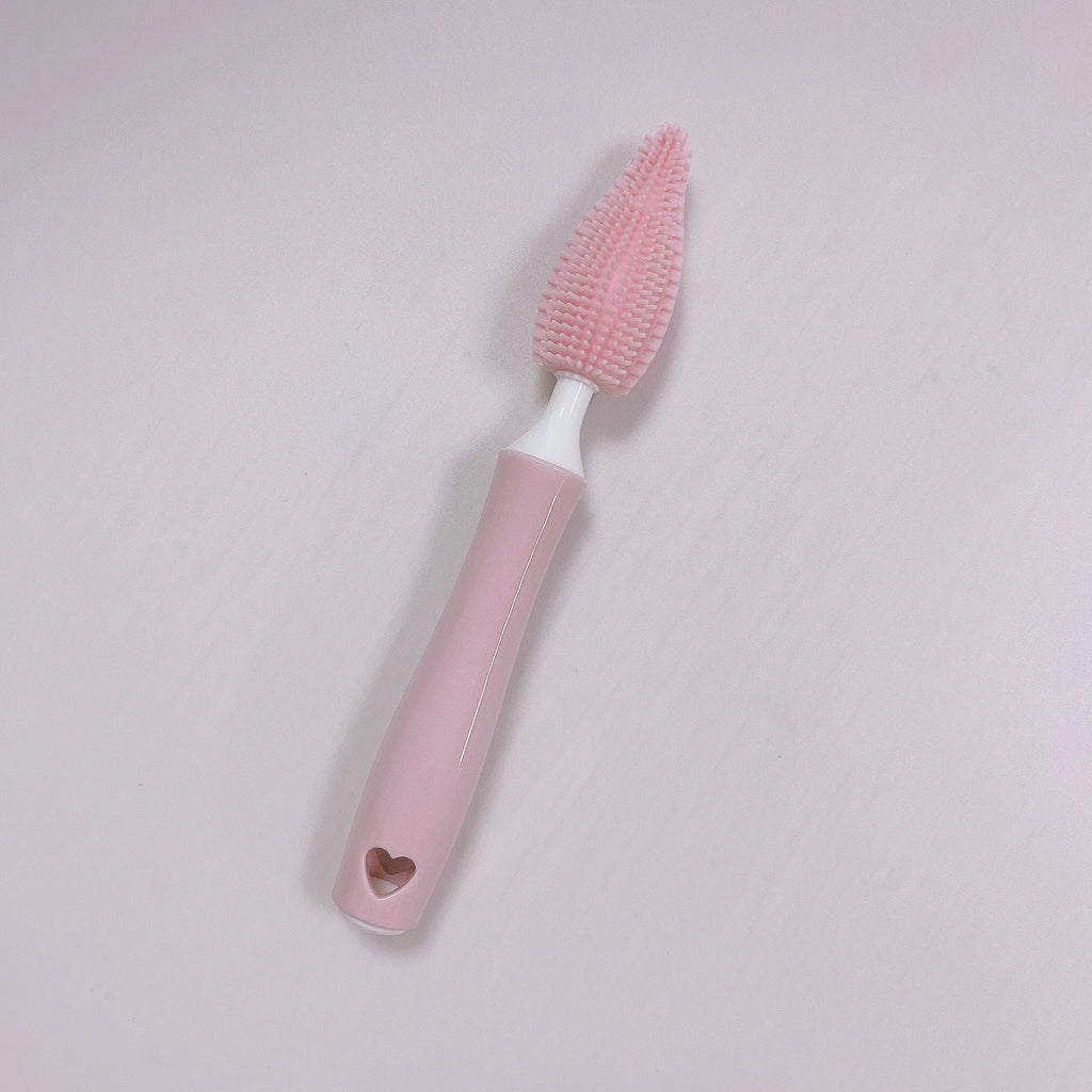Three silicone baby bottle brushes in blue, pink, and yellow with straw scrubber on white background