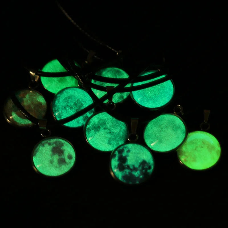 Luminous moon and star constellation pendant necklace with a silver-tone chain on a black background.