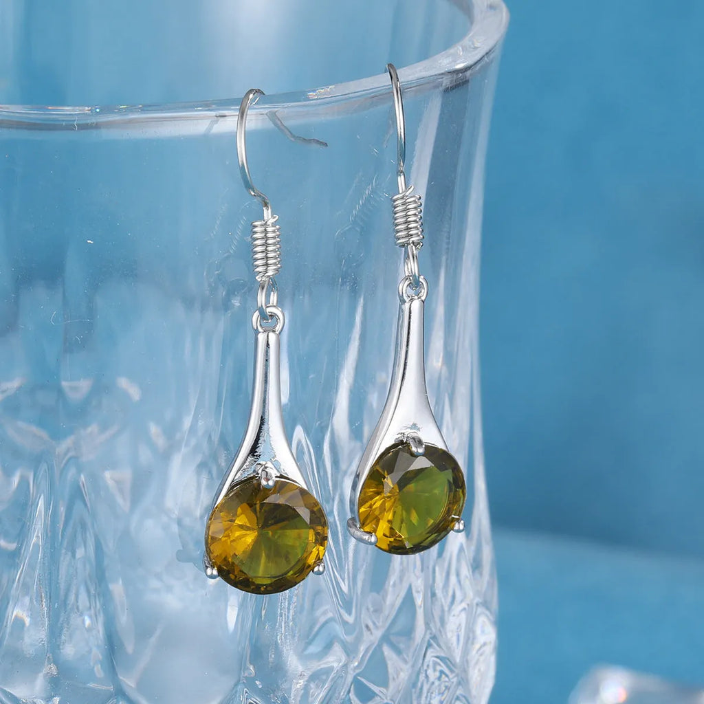 Olive green topaz coloured drop earrings with a water drop shape and retro style on a white background.