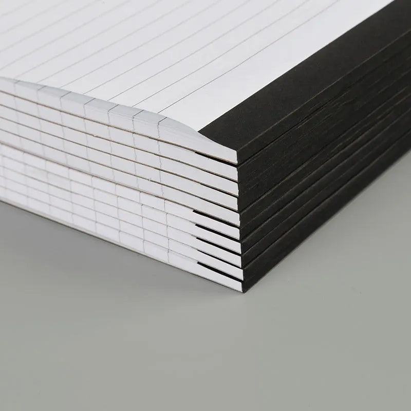 A4 tearable notebook with soft cover open to show gridded ivory white paper inside.