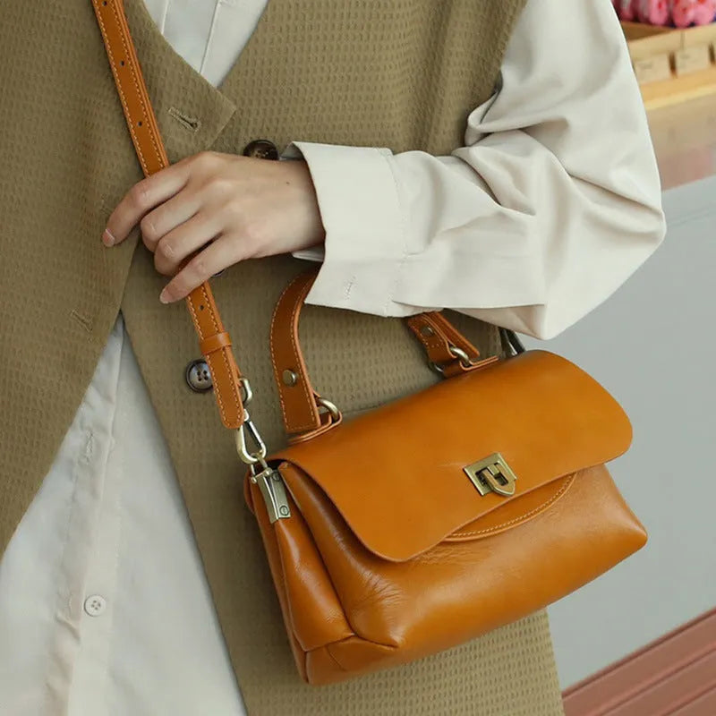 Brown retro style women's leather handbag with saddle back shape and double shoulder straps