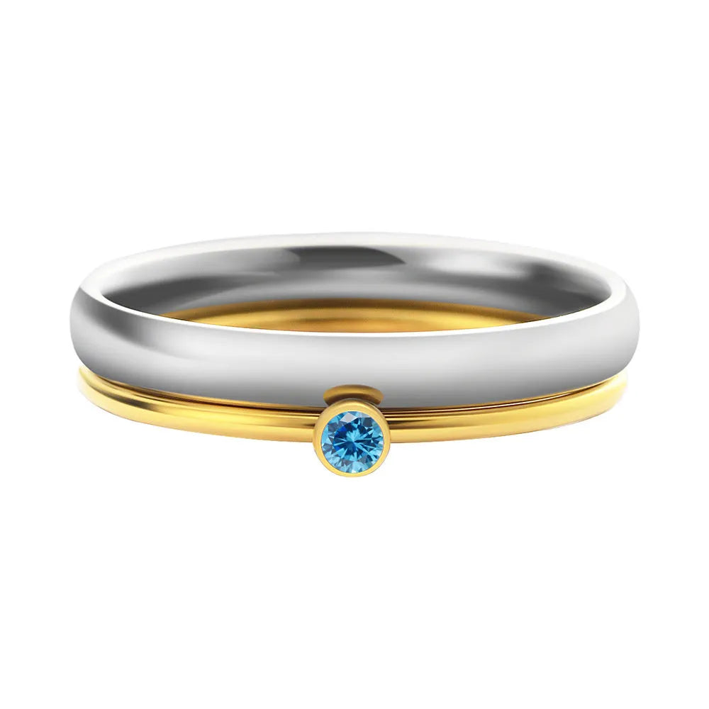A geometric titanium steel ring with a December birthstone and gold-coloured handle on a plain background.