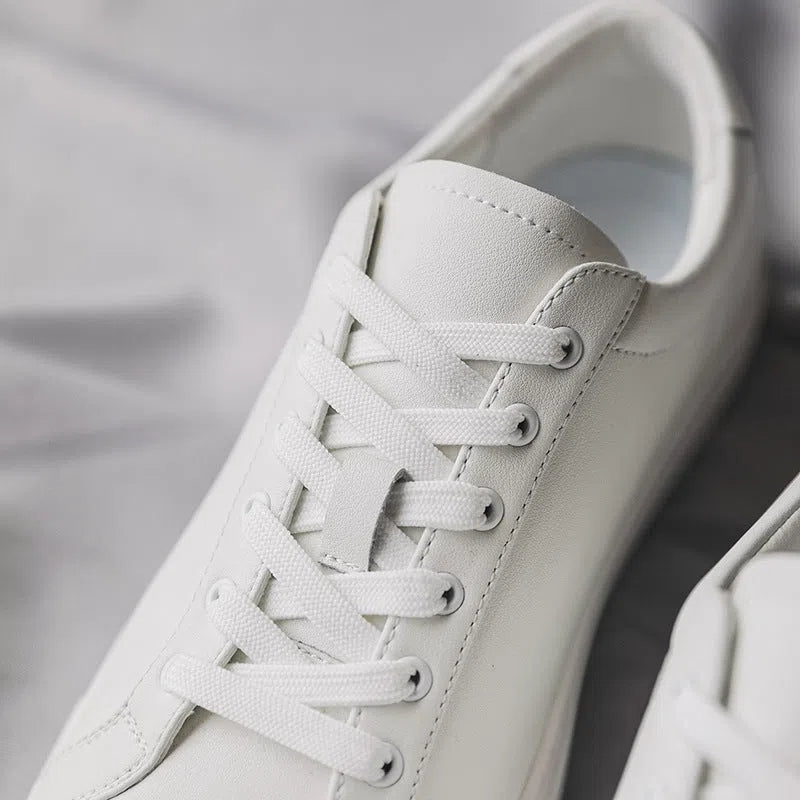 White flat-soled cowhide sneakers with stitching detail and round toe