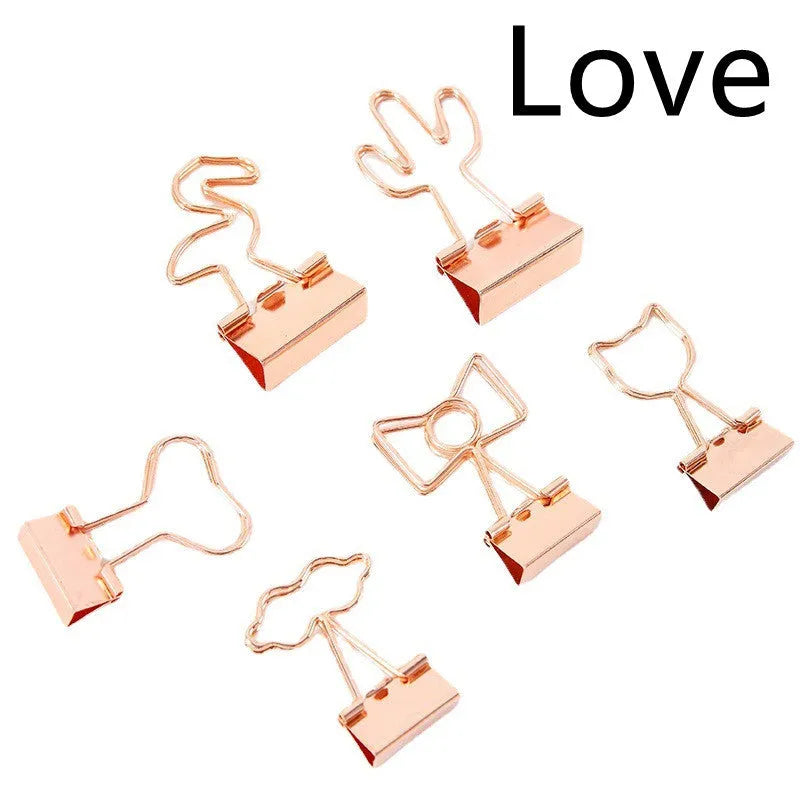 Gold metal stationery clip with a long tail, showing a decorative flamingo design.