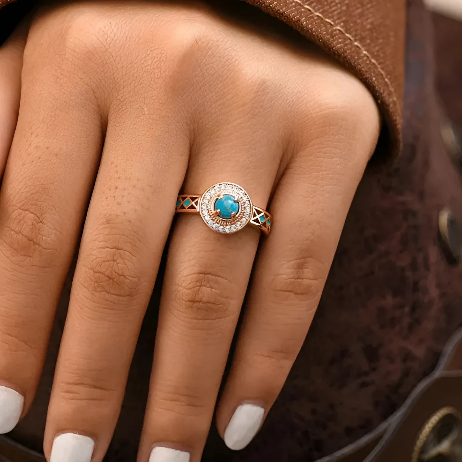 Women's turquoise ethnic geometric ring with micro inlaid zircon in rose gold coloured copper on a white background.