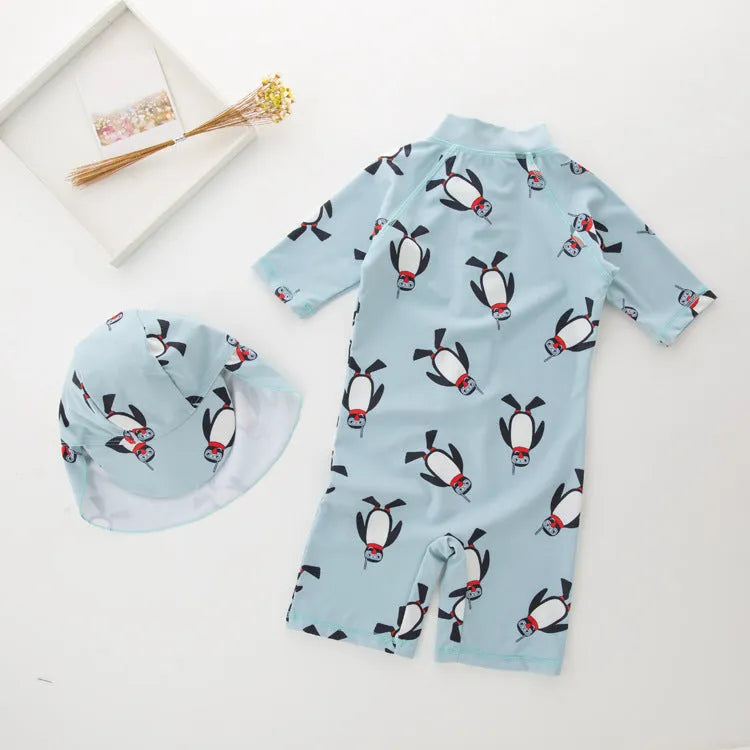 Boy's penguin print long sleeve swimsuit two-piece set with matching swim cap.