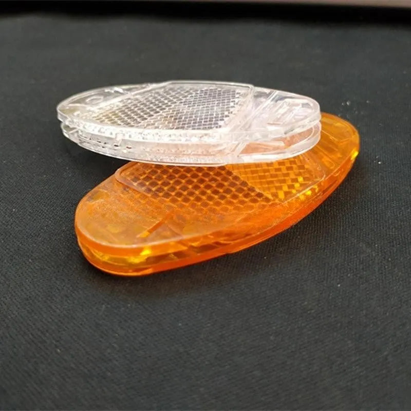 Yellow and white bicycle reflector decorations showing front and rear spoke mounting for night-time visibility