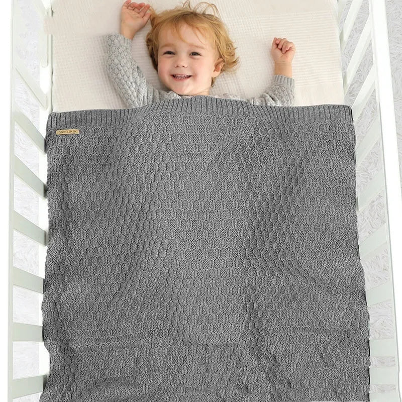Solid colour infant hug blanket with raised 3D line texture, shown in beige khaki colour, measuring 70 by 90 centimetres.