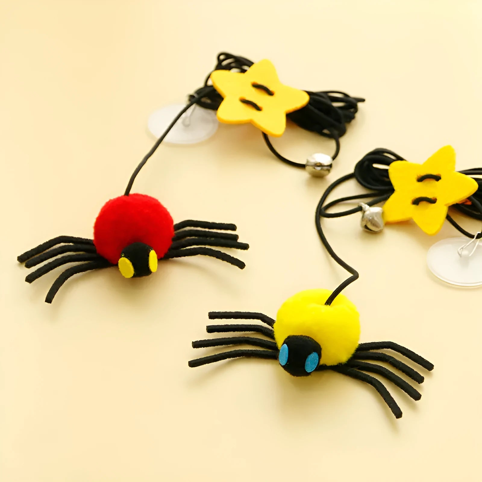 Cat toy with elastic rope hanging over a door, featuring a feather wand, jingle bell, and dangling spider attachment.